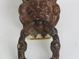 a metal door knocket with a lion head on it