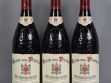 trois bouteilles de vin rouge sont posées sur une table en verre