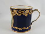 a close up of a blue cup with gold decoration on it