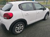 a small white car parked on the side of the road