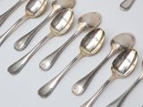 several silver spoons and spoon spoons are lined up on a table