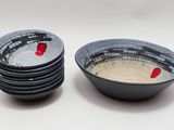 four black and white bowls with red designs on them on a white surface