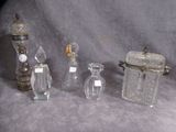 five glass bottles and a small glass jar on a table