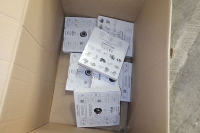 une boîte en carton remplie d'appareils électroniques posée par terre