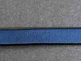a close up of a blue leather belt on a gray surface