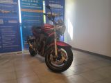 une moto rouge garée devant un mur bleu