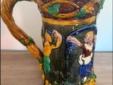 a ceramic mug with a painting on it on a table