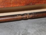 a rusted pipe on the floor next to a bed