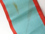a close up of a blue and orange table runner on a white table