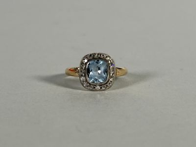 a gold ring with a blue topaz stone surrounded by diamonds