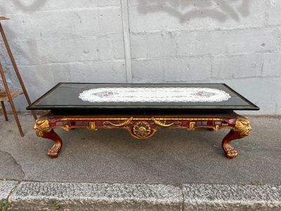 a coffee table with a black top and gold decorations on it