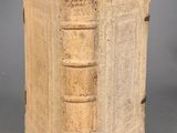 un vieux livre posé sur une table à côté d'un mur gris