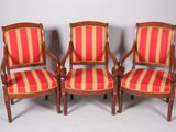 trois chaises en bois recouvertes d'un tissu à rayures rouges et jaunes