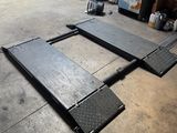 un gros plan sur le sol d'un garage, avec de nombreux pneus en arrière-plan