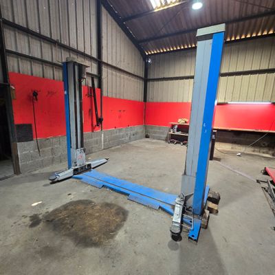 a couple of blue lifts in a building with red walls