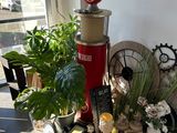 une borne d'incendie rouge posée sur une table devant une fenêtre