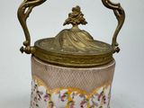 a gold and pink vase with a handle on a white background
