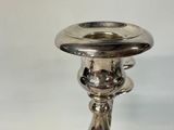 a silver candle holder that is on a table