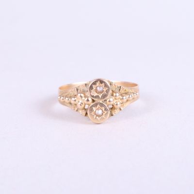gros plan d'une bague en or sur une surface blanche