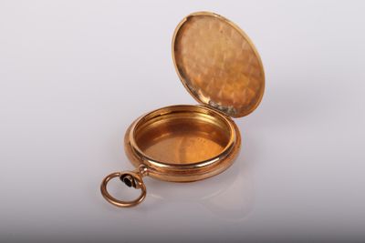 un cadenas doré contenant une clé, posé sur une surface blanche