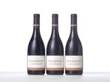 three bottles of wine sitting on top of a white table