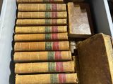 Plusieurs vieux livres se trouvent dans une boîte blanche posée sur une table