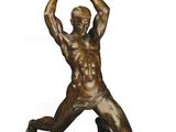 statue en bronze représentant un homme tenant un ballon de football dans ses mains
