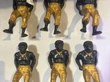 several figurines of black and gold football players on a white surface