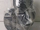 several rolls of black yarn wrapped in plastic bags on a white surface