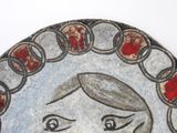 a picture of a painting of a woman on a plate