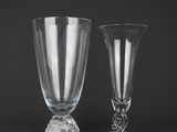 two clear glass goblets sitting on top of a black table