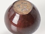 a brown vase with a brown lid on a white surface