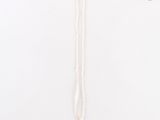 un collier blanc composé d'une chaîne dorée et d'une perle blanche