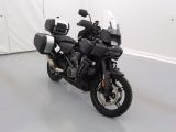 a black motorcycle parked in a room with a white wall