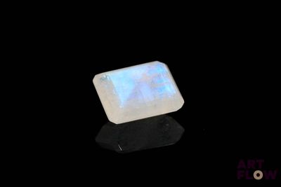 une pierre oplite blanche sur une surface noire