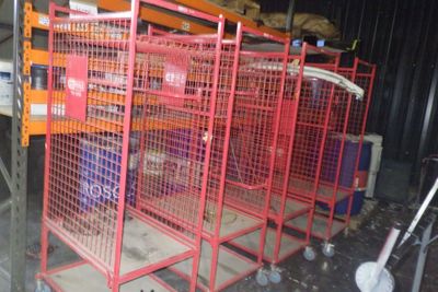 de nombreuses cages posées à même le sol dans un entrepôt