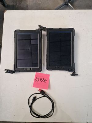 two cell phones sitting on a table with a note attached to it