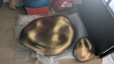 une chaise dorée posée par terre à côté d'un téléviseur