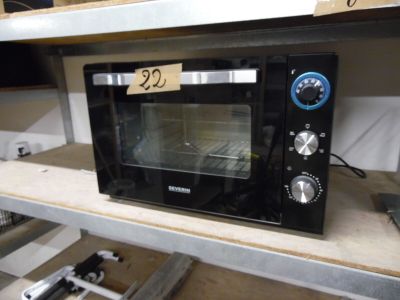 un micro-ondes posé sur une étagère, avec une étiquette de prix dessus