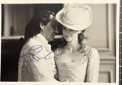 une vieille photo représentant un homme et une femme, celle-ci portant une robe et un chapeau
