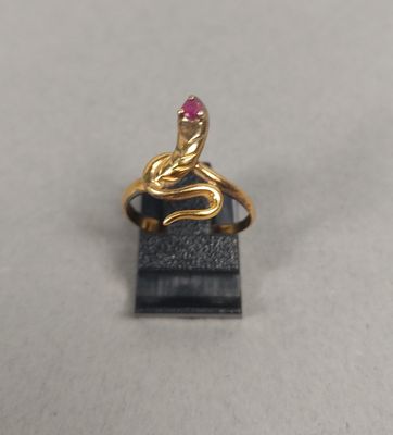 un gros plan d'une bague en or sertie d'une pierre rose
