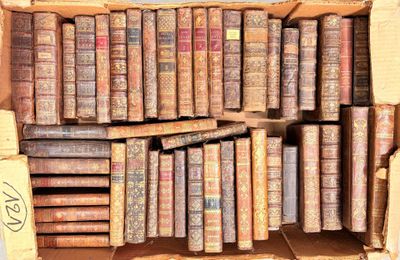 une boîte remplie de vieux livres posée sur une table