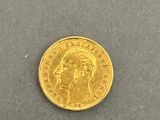 a close up of a gold coin on a gray surface