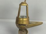 quelqu'un tient un petit objet métallique dans lequel se trouve un verre