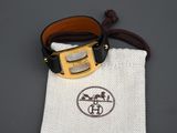 une ceinture en cuir avec une boucle dorée et une pochette blanche