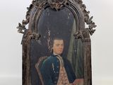 une vieille photo représentant un homme en manteau bleu, assis sur une chaise