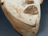 a close up of a clay mask on a table