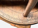 a close up of a sundialer on a wooden table