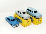 three toy cars are sitting on top of boxes on a white surface