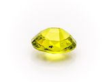 a close up of a yellow diamond on a white surface